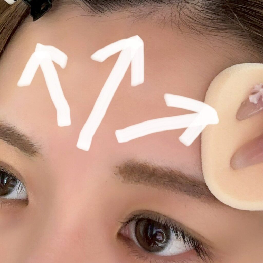 おでこにパウダーファンデーションをつける様子